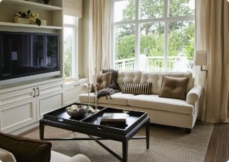 Bright living room with a cream sofa and tall white-framed windows
